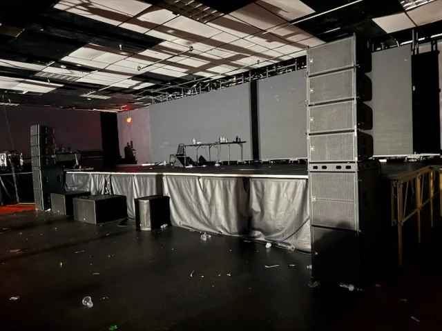 Post-event debris across the dark floor near the stage