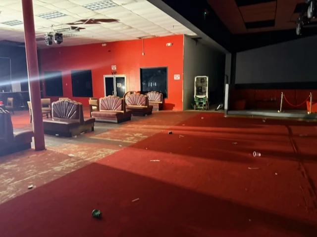 Lounge seating and red wall with post-event debris on the floor