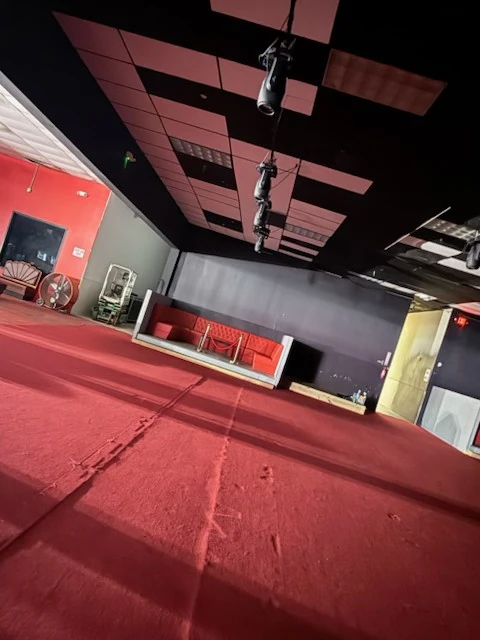 Open red-carpeted event floor facing the booth seating