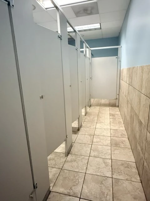 Restroom walkway and cubicles after cleanup