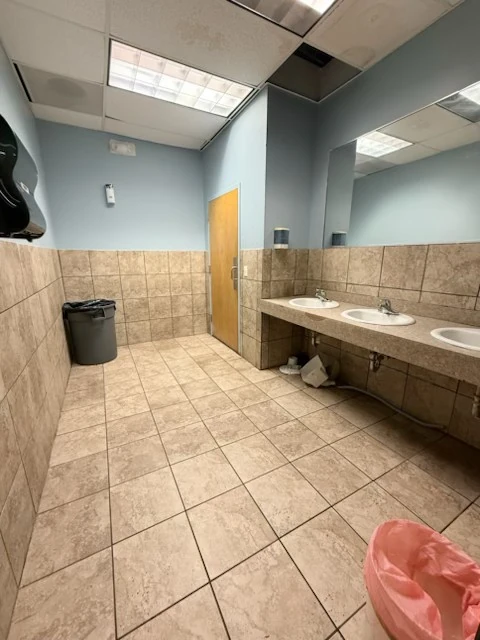 Restroom sinks and surrounding tiled floor after cleanup