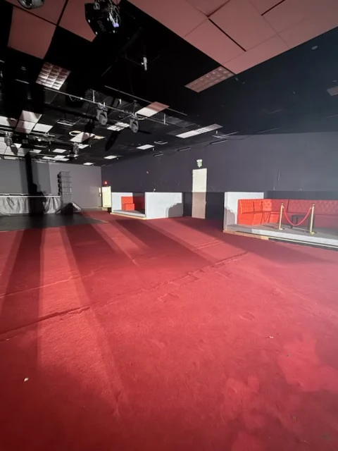 Cleared red-carpeted floor facing the booth seating