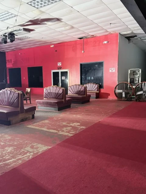 Lounge seats against the red wall with the surrounding floor cleared
